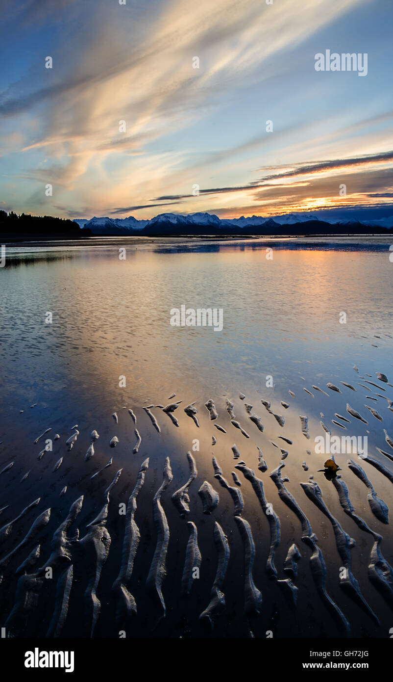 Pre alba la luce è riflessa sulle acque poco profonde di una marea piana di fango. Foto Stock