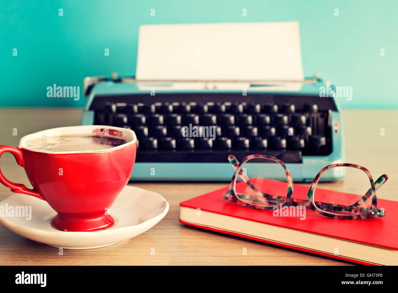 Macchina da scrivere Vintage, occhiali su notebook e la tazza di caffè Foto Stock