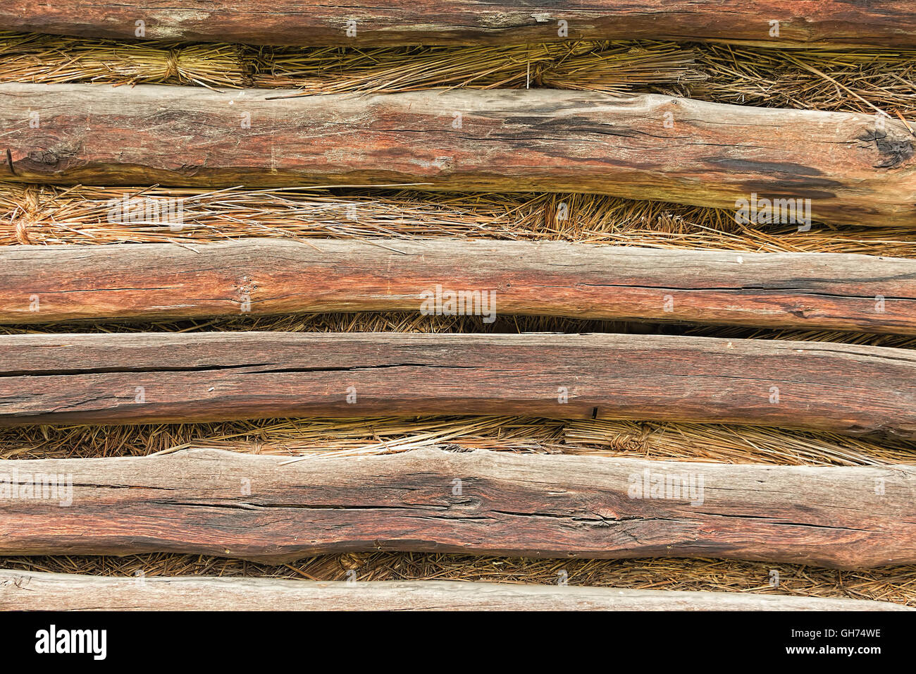 Rustico sfondo grunge, la parete della vecchia casa di campagna da travi di legno e paglia, la tradizionale tecnologia di costruzione. Foto Stock