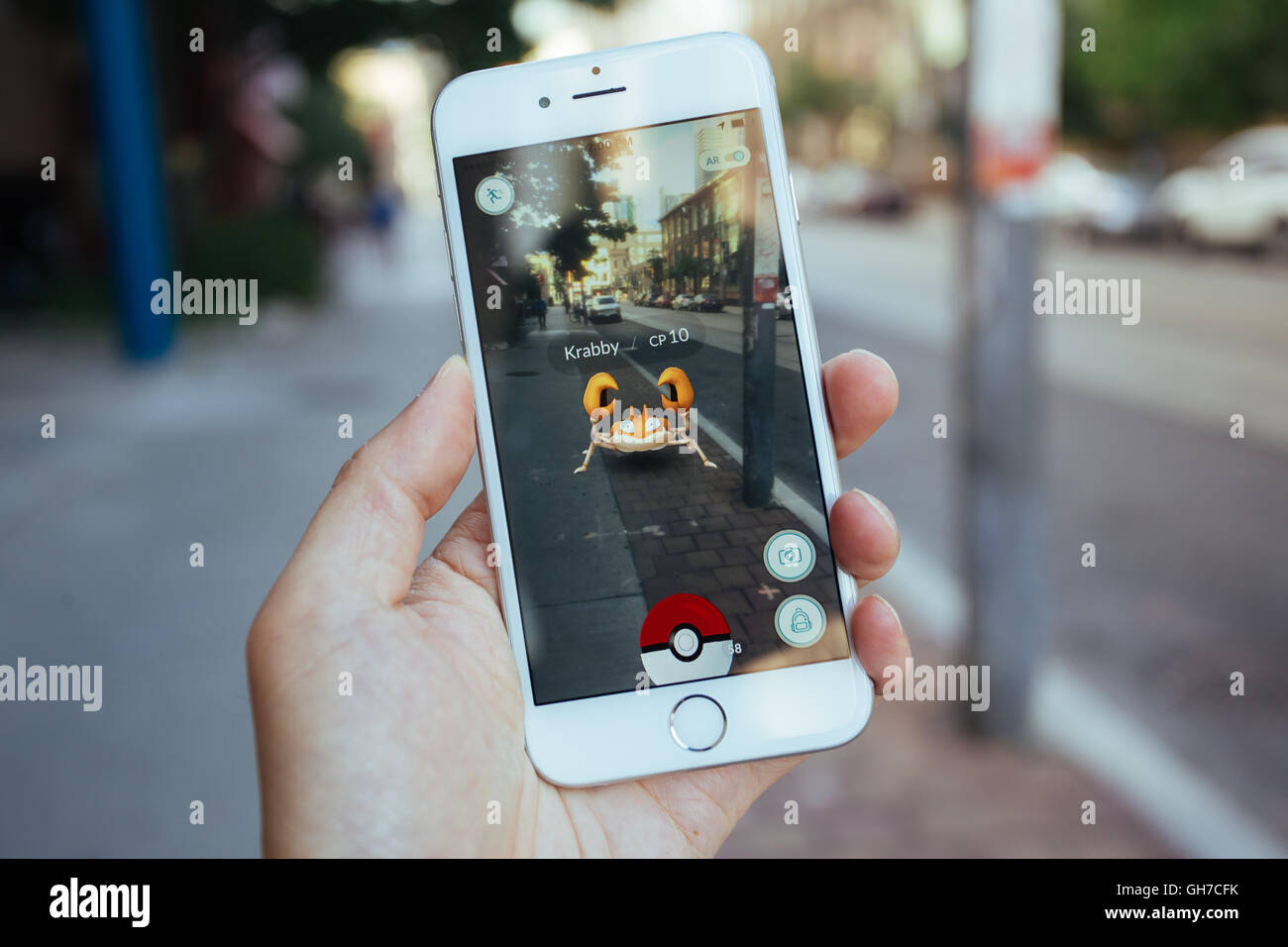 Giocare a Pokemon Go su uno smartphone Apple Foto Stock Giocare a Pokemon Go su uno smartphone Apple Foto Stock
