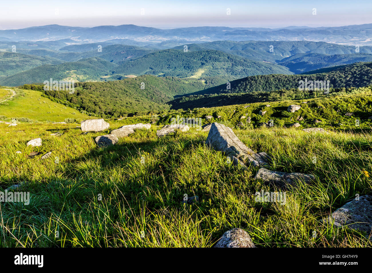 Paesaggio di montagna con pietre che stabilisce tra l'erba sul lato della collina Foto Stock
