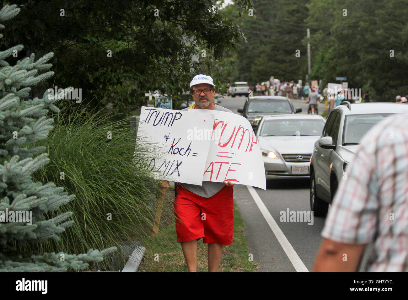 Osterville, Massachusetts, STATI UNITI D'AMERICA. 6 agosto 2016. Un manifestante porta segni mentre marcia in opposizione al repubblicano candidato presidenziale Donald Trump, nei pressi di un fundraiser imprenditore William Koch hosting per Trump. Credito: Susan Pease/Alamy Live News Foto Stock