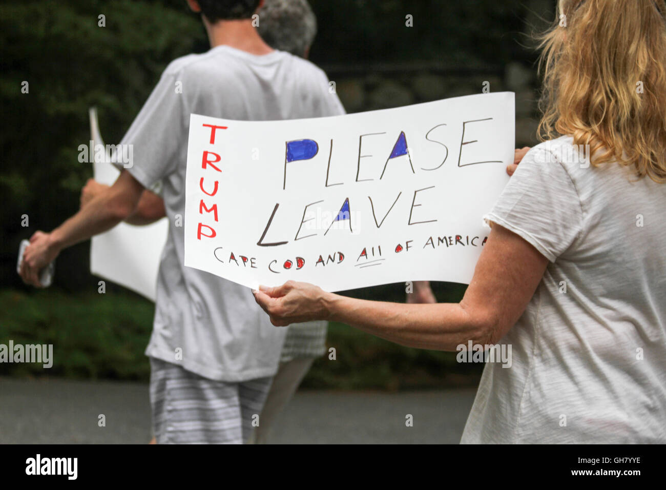 Osterville, Massachusetts, STATI UNITI D'AMERICA. 6 agosto 2016. Un manifestante detiene un segni opposti presidenziale repubblicano nominee Donald Trump, nei pressi di un fundraiser imprenditore William Koch hosting per Trump. Credito: Susan Pease/Alamy Live News Foto Stock