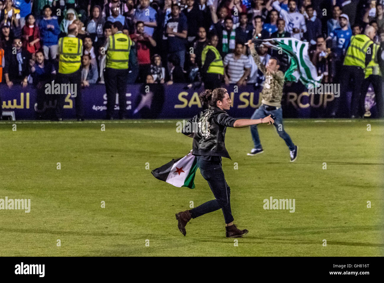 Londra, Regno Unito. 8 agosto, 2016. Protester invade il passo tenendo bandiera della Siria durante l Arabia Super Cup football match finals Al-Ahli vs Al-Hilal a Craven Cottage, Fulham Football Club Credito: Guy Corbishley/Alamy Live News Foto Stock