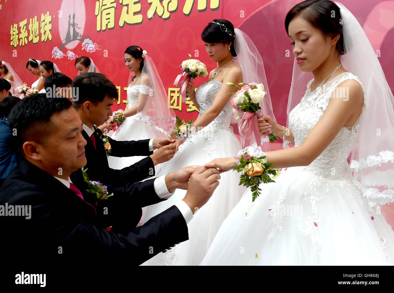 Zhengzhou, la Cina della Provincia di Henan. Il 9 agosto, 2016. Neo-mer coppie scambiare gli anelli di nozze a un gruppo cerimonia di matrimonio in Zhengzhou, capitale della Cina centrale della Provincia di Henan, e il Agosto 9, 2016. Un gruppo cerimonia di nozze si è tenuto qui per città metropolitana costruttori sul Festival Qixi o cinese il giorno di San Valentino. Credito: Li Un/Xinhua/Alamy Live News Foto Stock