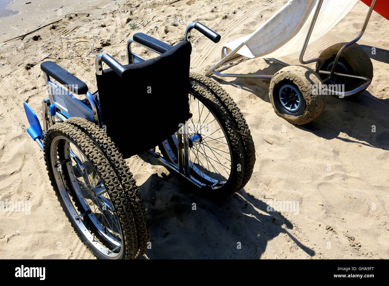 Due sedie a rotelle speciali sulla sabbia della spiaggia del mare Foto Stock