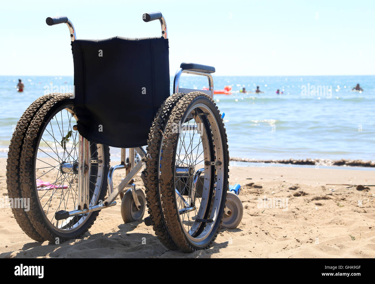 Sedia a rotelle alluminio sulla sabbia della spiaggia del mare Foto Stock
