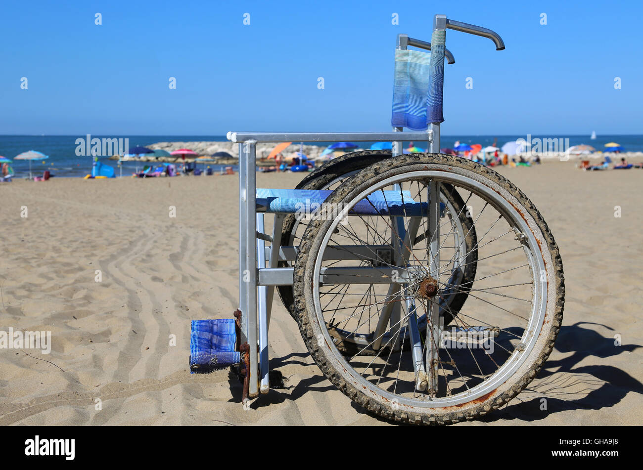 Sedia a rotelle sulla sabbia della spiaggia del resort Foto Stock