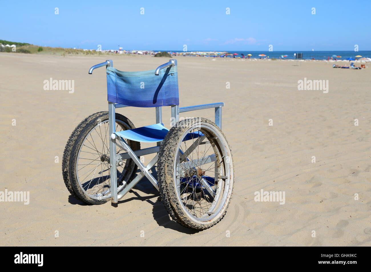 Moderne sedie a rotelle di alluminio con ruote speciali con pneumatici doppi in movimento sulla spiaggia di sabbia Foto Stock