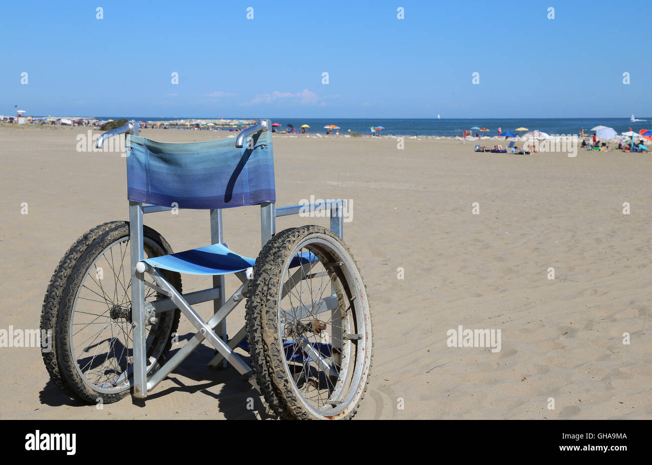 Alluminio sedia a rotelle sulla sabbia della spiaggia in estate Foto Stock