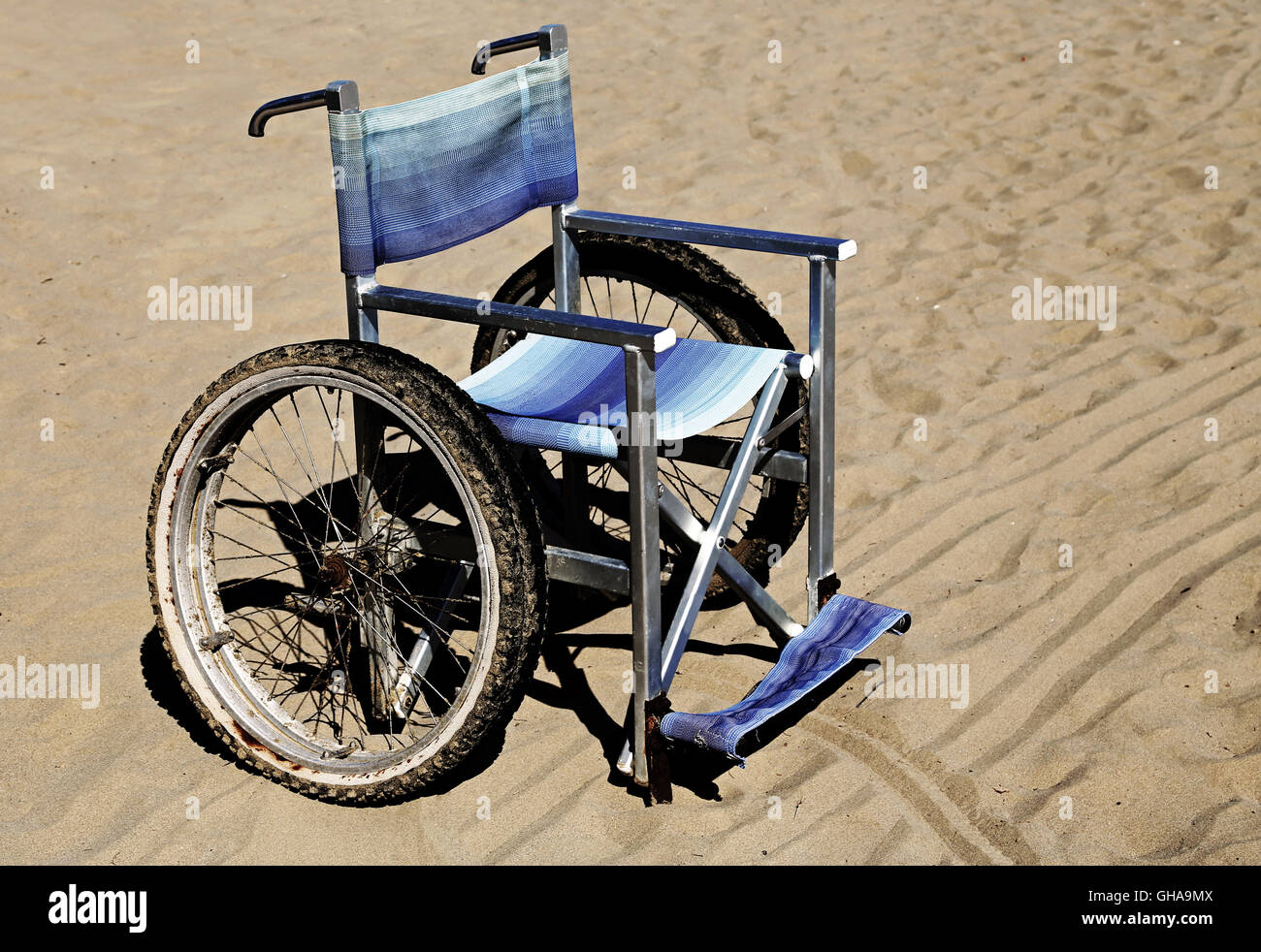 Sedia a rotelle sulla sabbia della spiaggia in estate Foto Stock