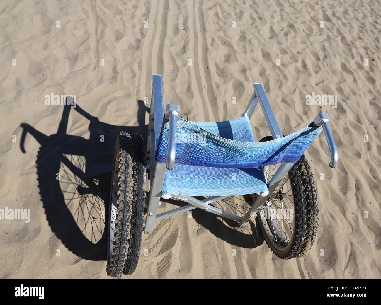 Sedia a rotelle di alluminio sulla sabbia della spiaggia Foto Stock