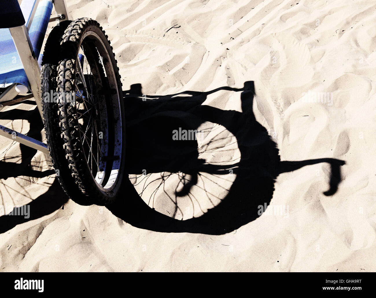 Ombra di una sedia a rotelle sulla spiaggia Foto Stock