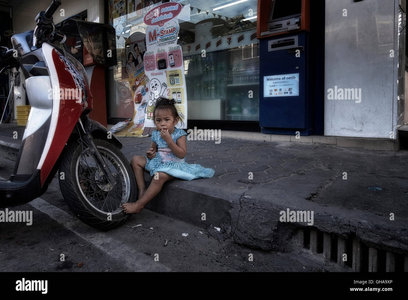 In Tailandia la povertà. Bambino mangiare sul marciapiede in un centro Thai delle baraccopoli. Thailandia poveri. S. E. Asia Foto Stock