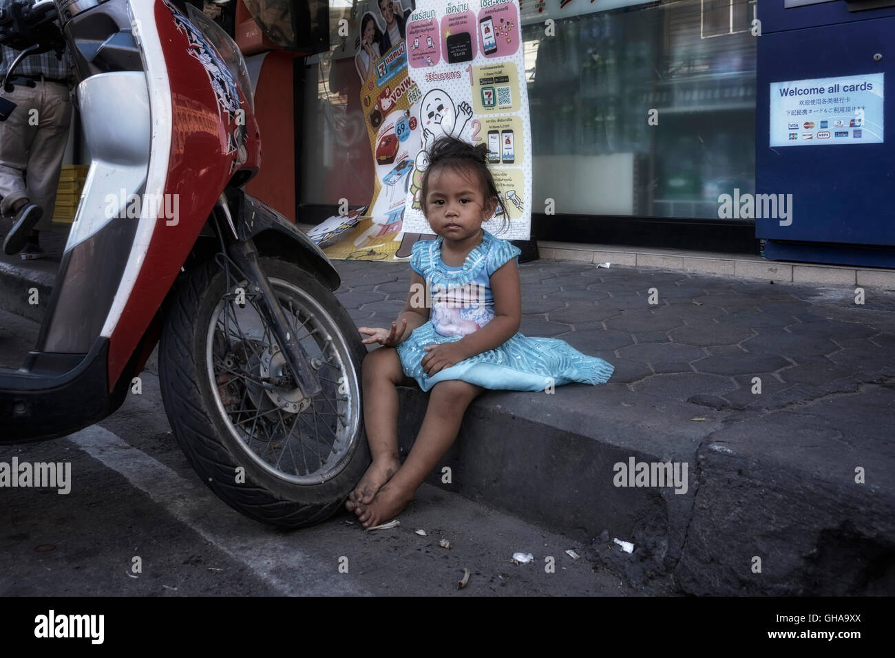 In Tailandia la povertà. Bambino mangiare sul marciapiede in un centro Thai delle baraccopoli. Thailandia poveri. S. E. Asia Foto Stock