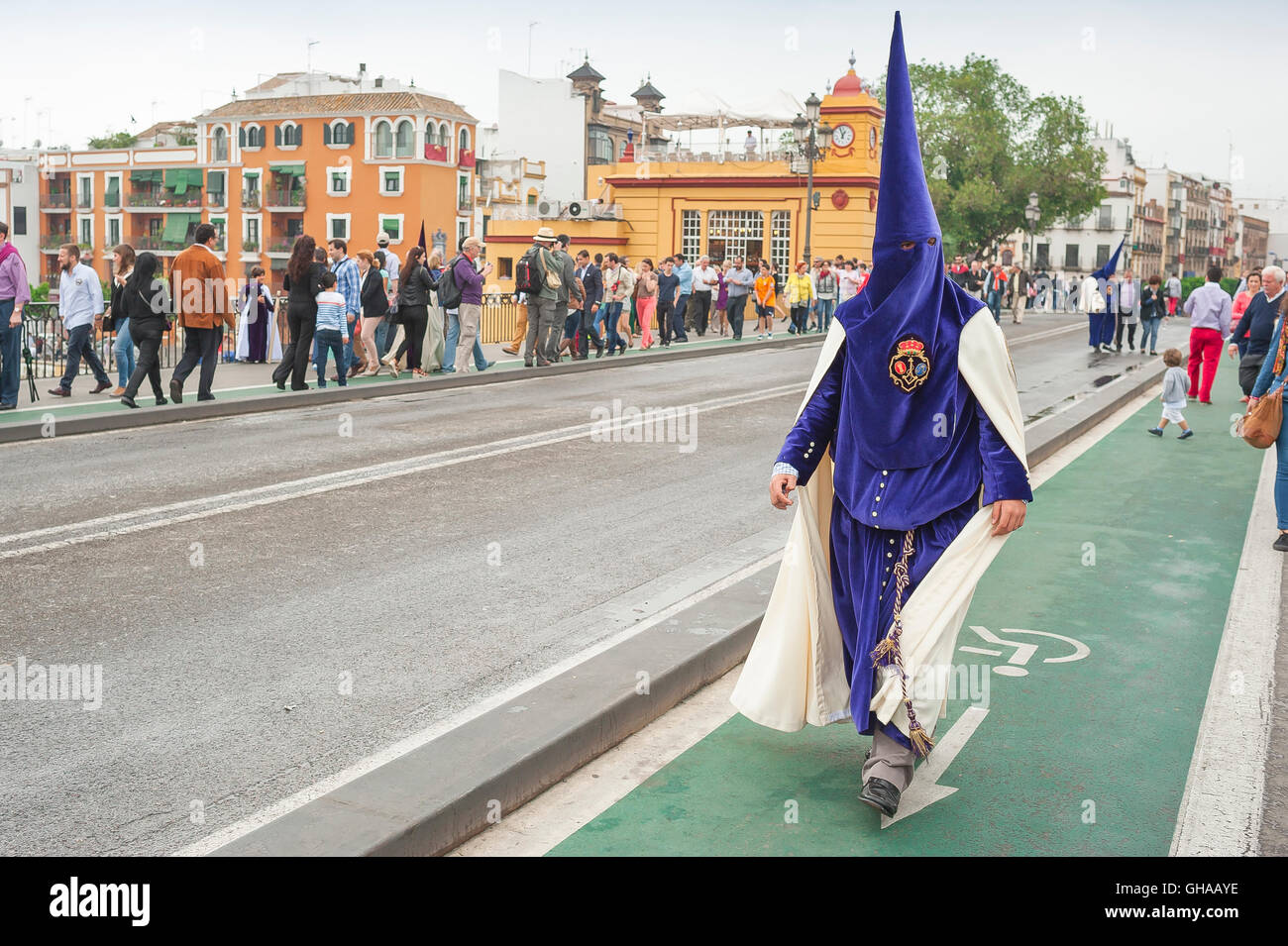 Siviglia Pasqua, un membro di una cofradia incappucciata (fratellanza) cammina per partecipare alla sua processione nel festival della settimana Santa di Pasqua a Siviglia, Spagna. Foto Stock