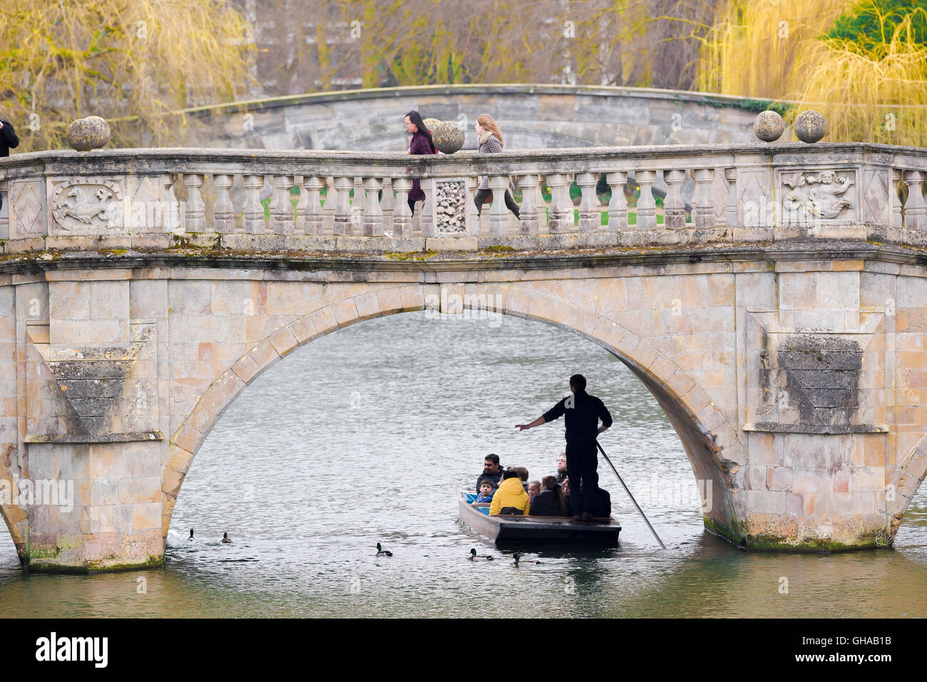 In un inizio di mattina di primavera a Cambridge nel Regno Unito, i turisti in un viaggio in un punt lungo il fiume Cam, scivolando sotto il ponte di Chiara. Foto Stock