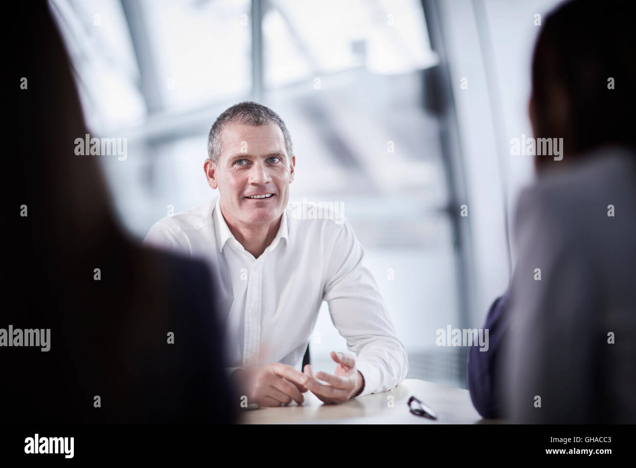 Imprenditore sorridente ascolto in riunione Foto Stock
