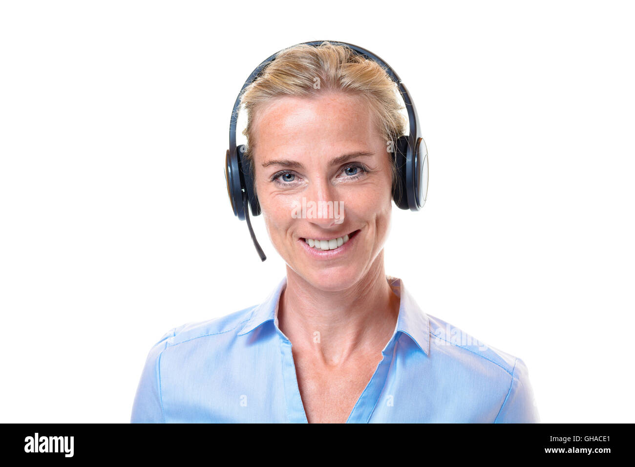 Sorridente splendido pelo corto biondo donna adulta in blu blusa con cuffia telefonica funziona come un servizio di assistenza clienti representati Foto Stock