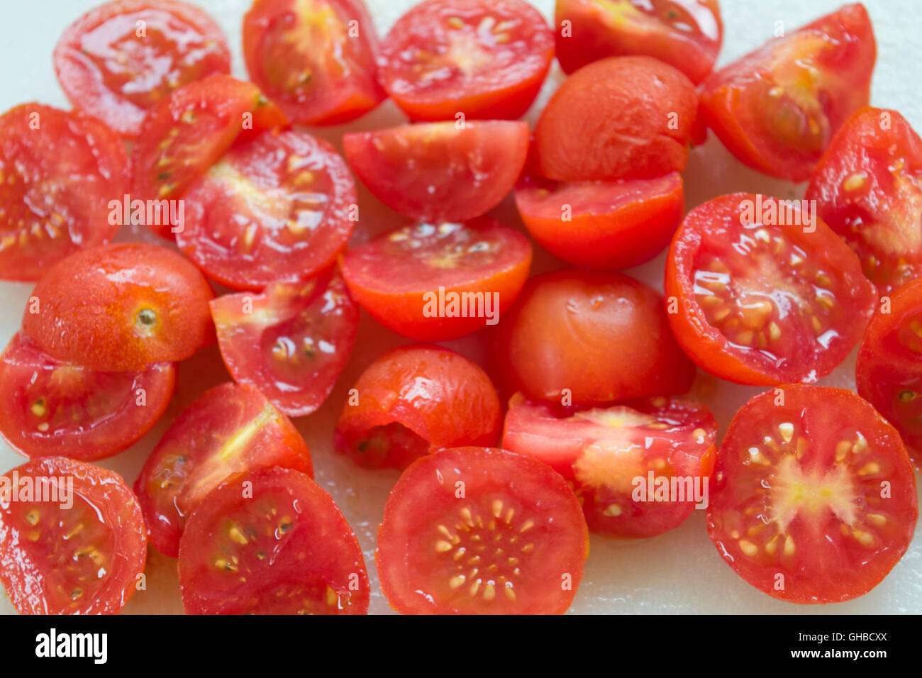 Freschi pomodori ciliegini tagliati a metà per preparare insalate estate Foto Stock