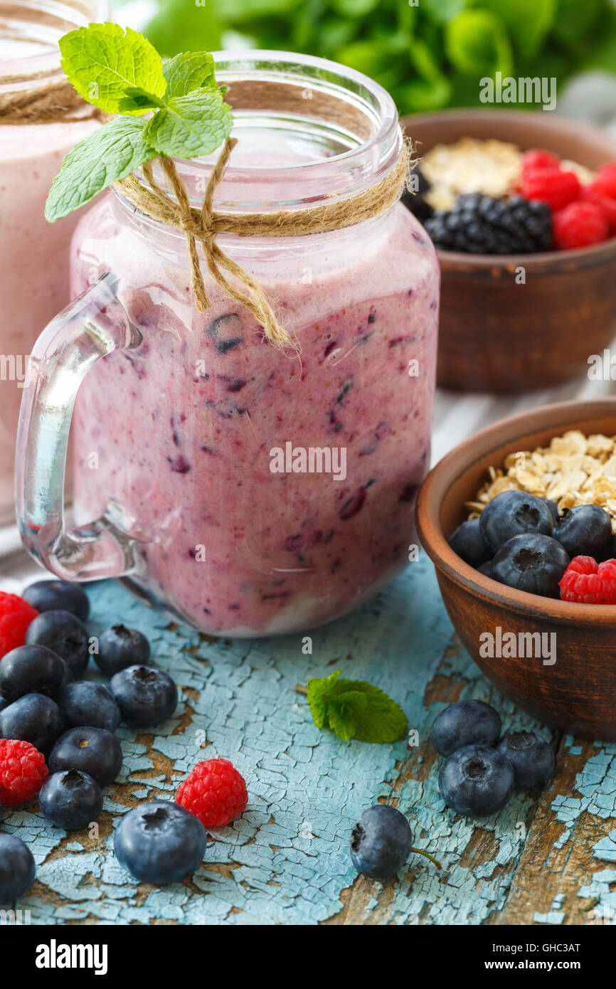 Benessere e perdita di peso concetto, berry smoothie e farina di avena sul tavolo di legno con ingredienti Foto Stock