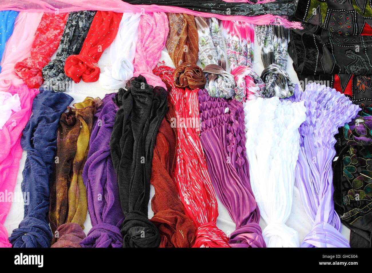 Colorate sciarpe impilati in un mercato in stallo Foto Stock