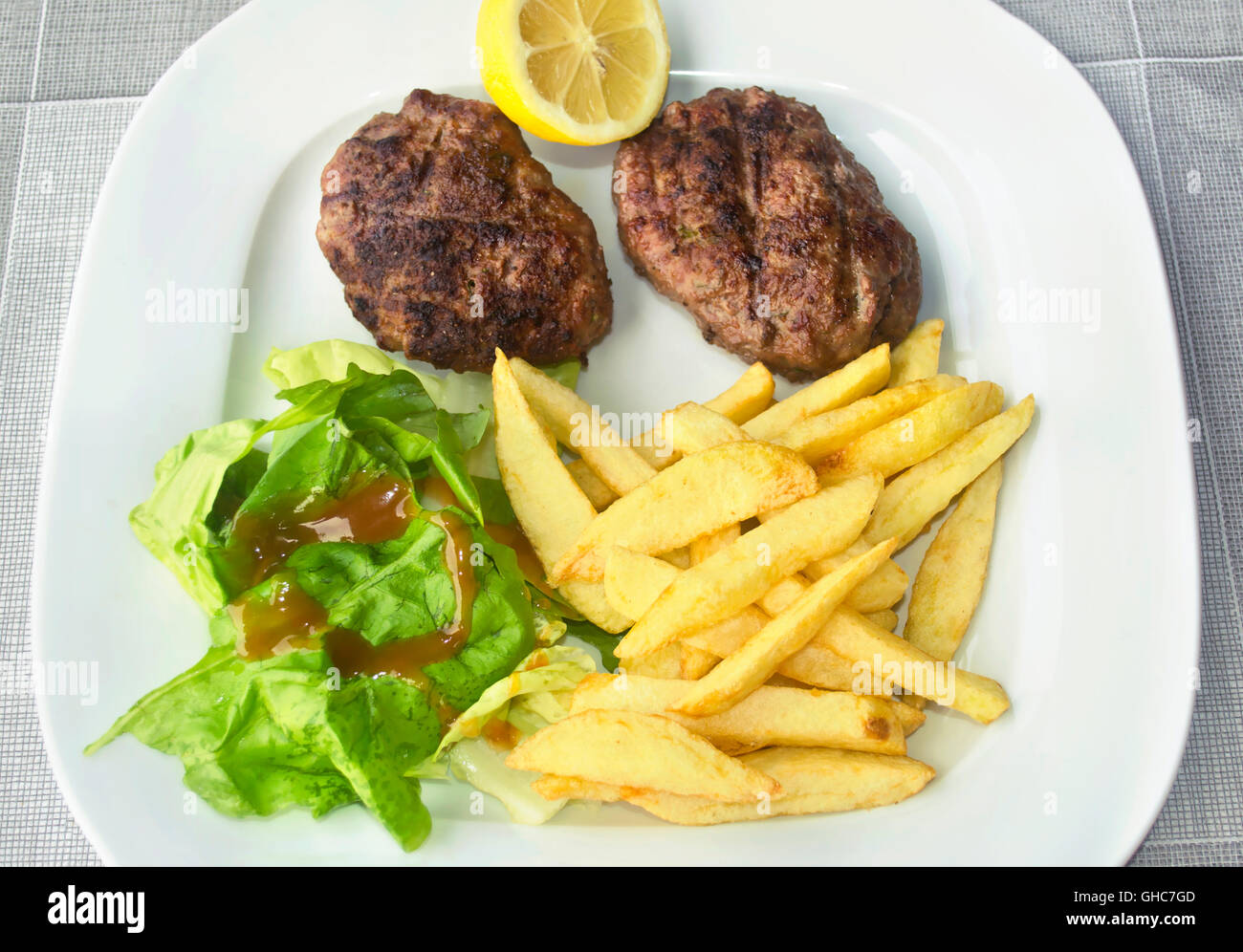 Hamburger alla griglia con patate fritte - cibo greco Foto Stock