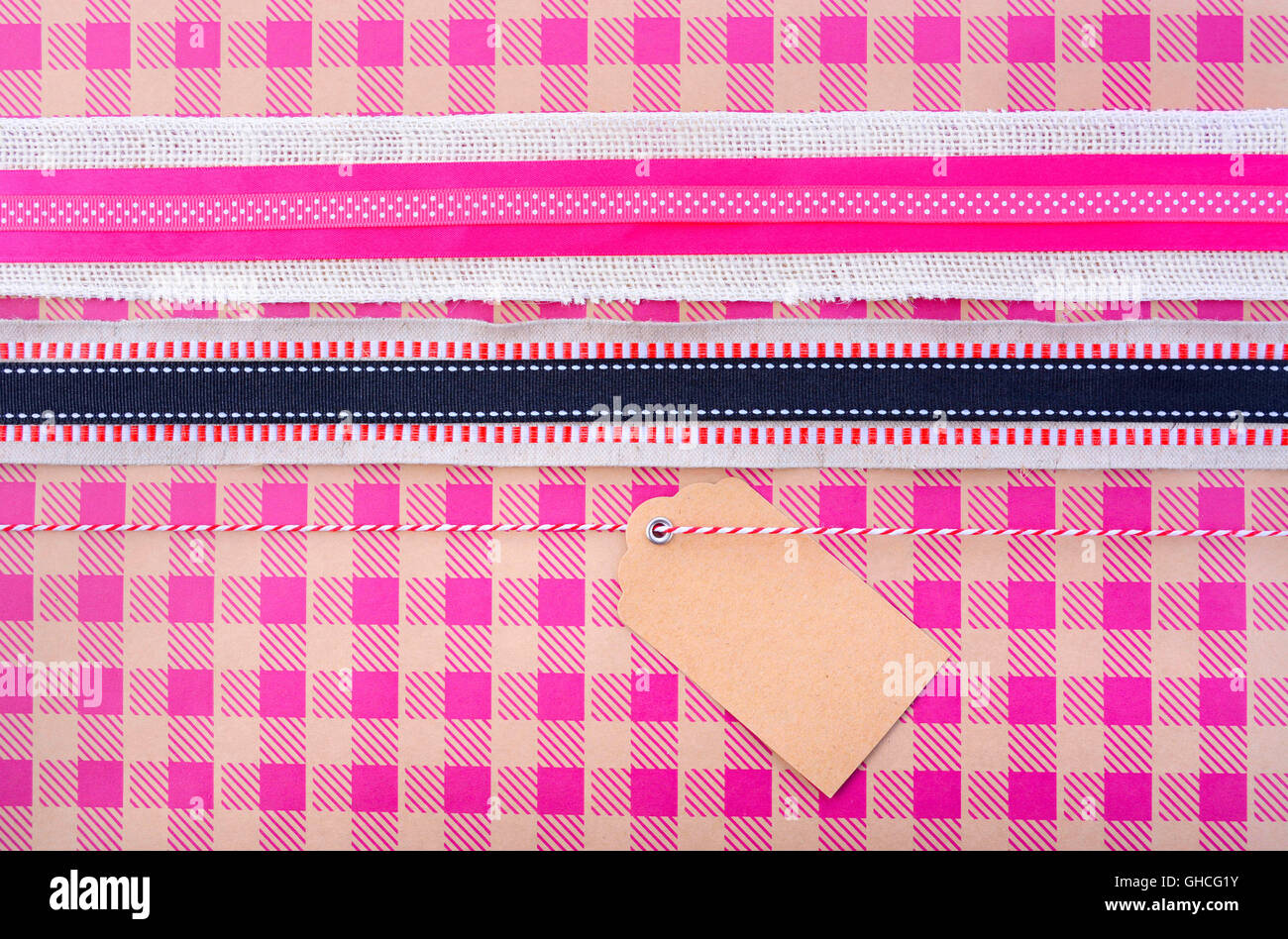 Moderno holiday saluto sfondo con close up vintage confezione regalo con nastri multipli e tag regalo in rosa controllare natur Foto Stock