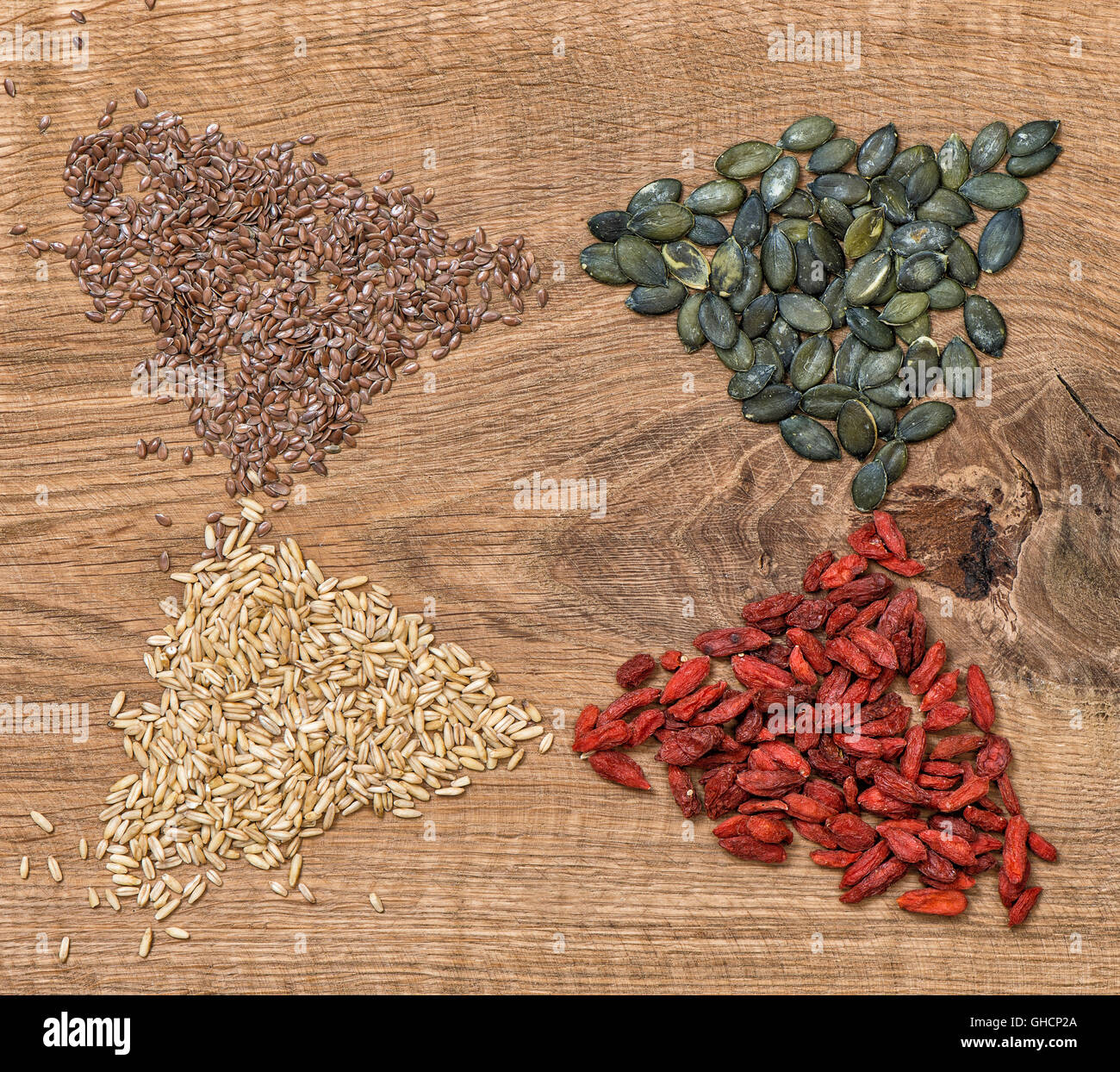 Superfoods sani. Pulire mangiare. Detox cibo. Bacche di Goji, avena, semi di lino, pumpkinseed su sfondo di legno. Foto Stock