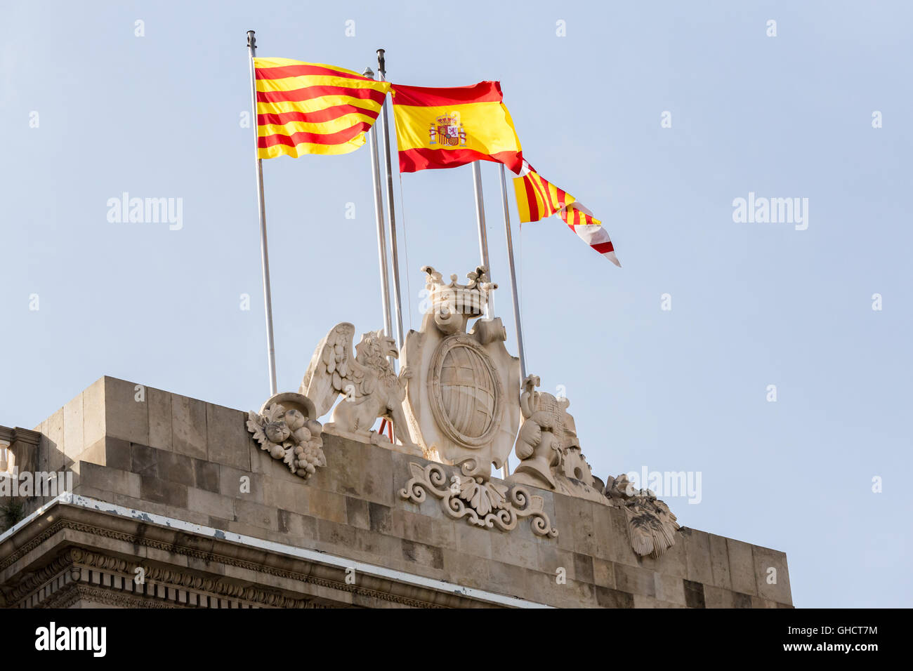 Barcellona, Spagna Municipio facciata in pietra stemma con le bandiere. Casa de la Ciutat nel centro del quartiere gotico con bandiere di Foto Stock