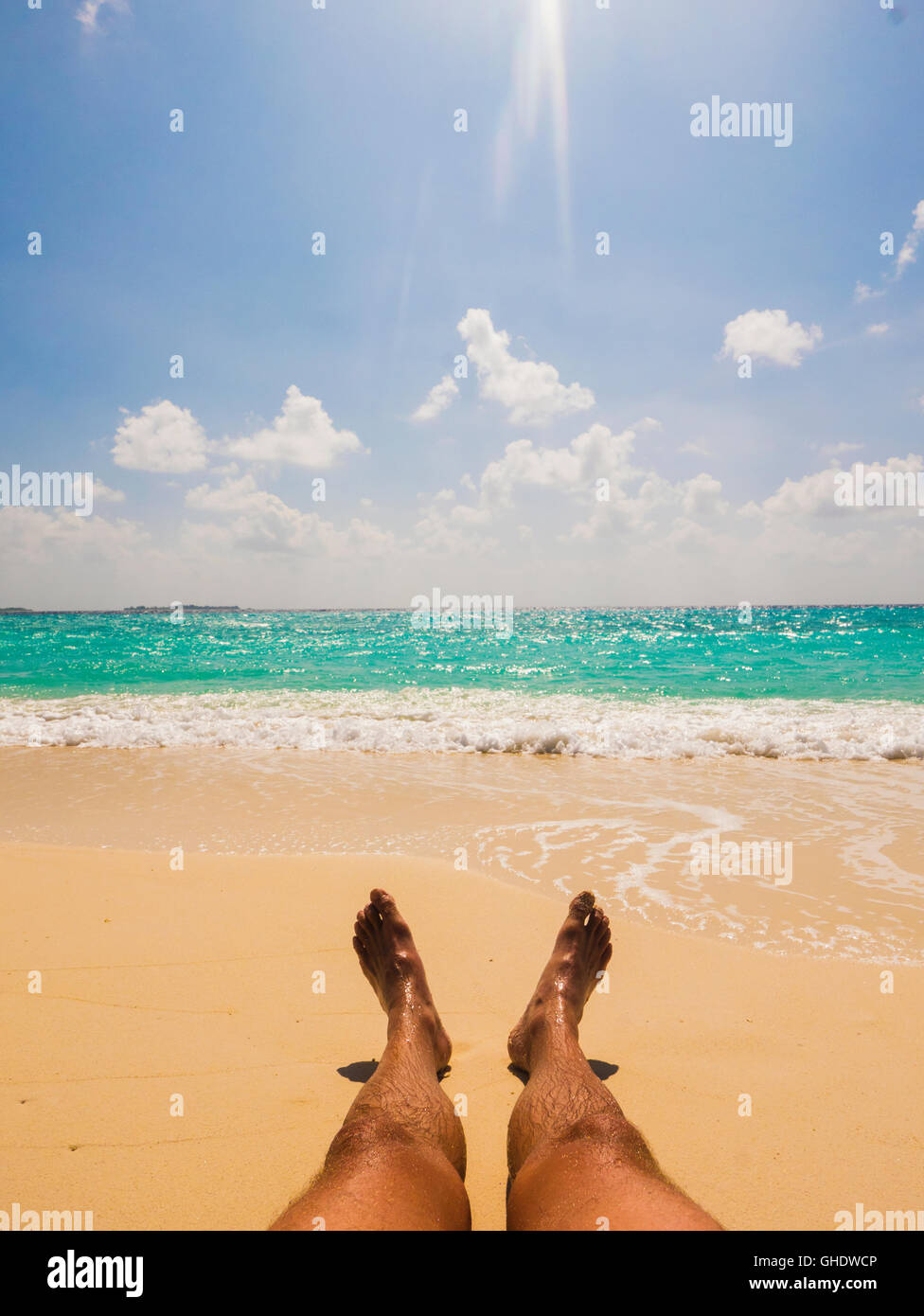 L uomo a prendere il sole sulla soleggiata spiaggia tropicale Foto Stock
