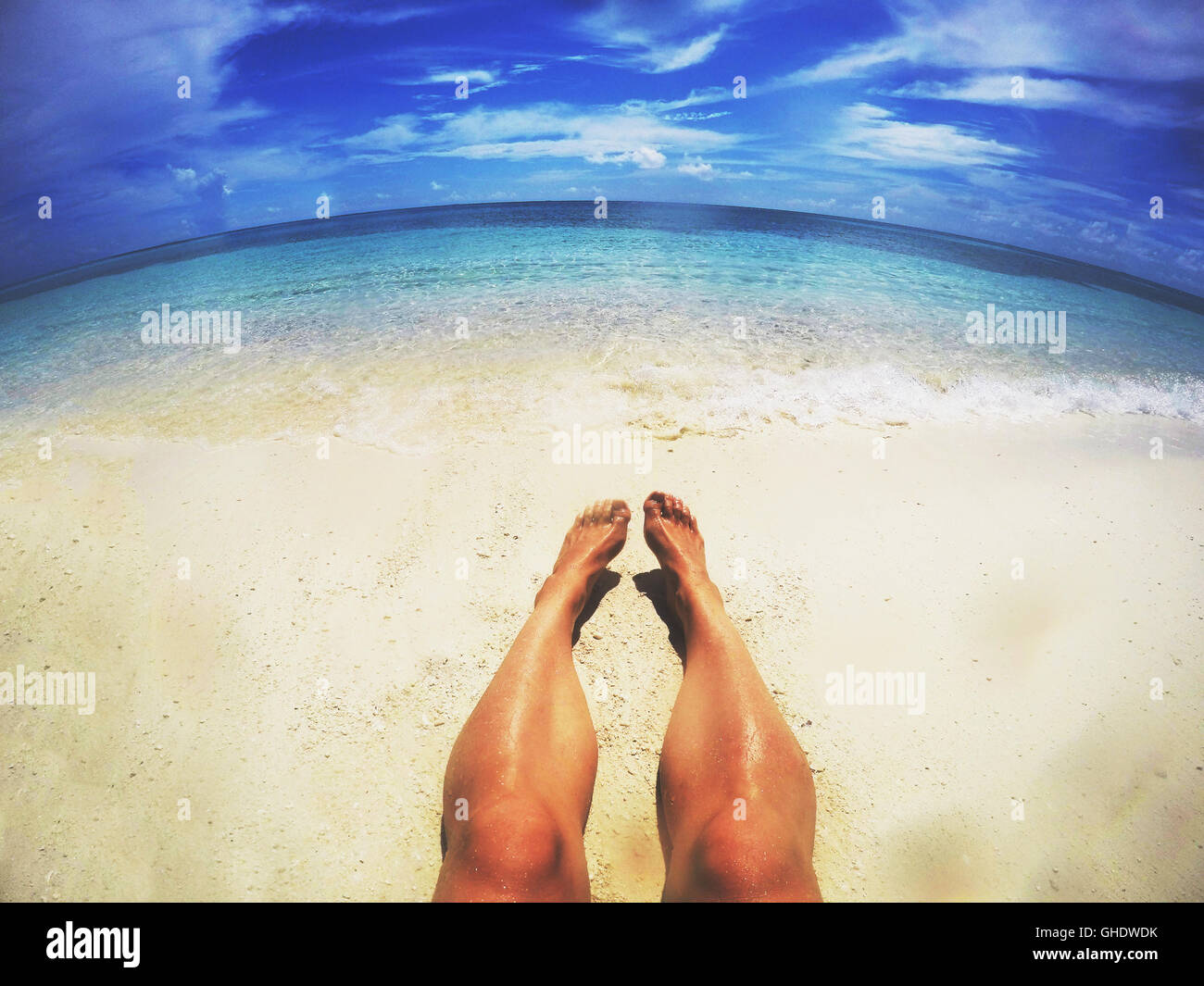 L uomo a prendere il sole sulla soleggiata spiaggia tropicale Foto Stock