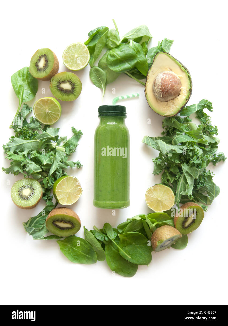 Imbottigliato frullato verde circondato con frutta e verdura compresi gli spinaci kale e avocado Foto Stock