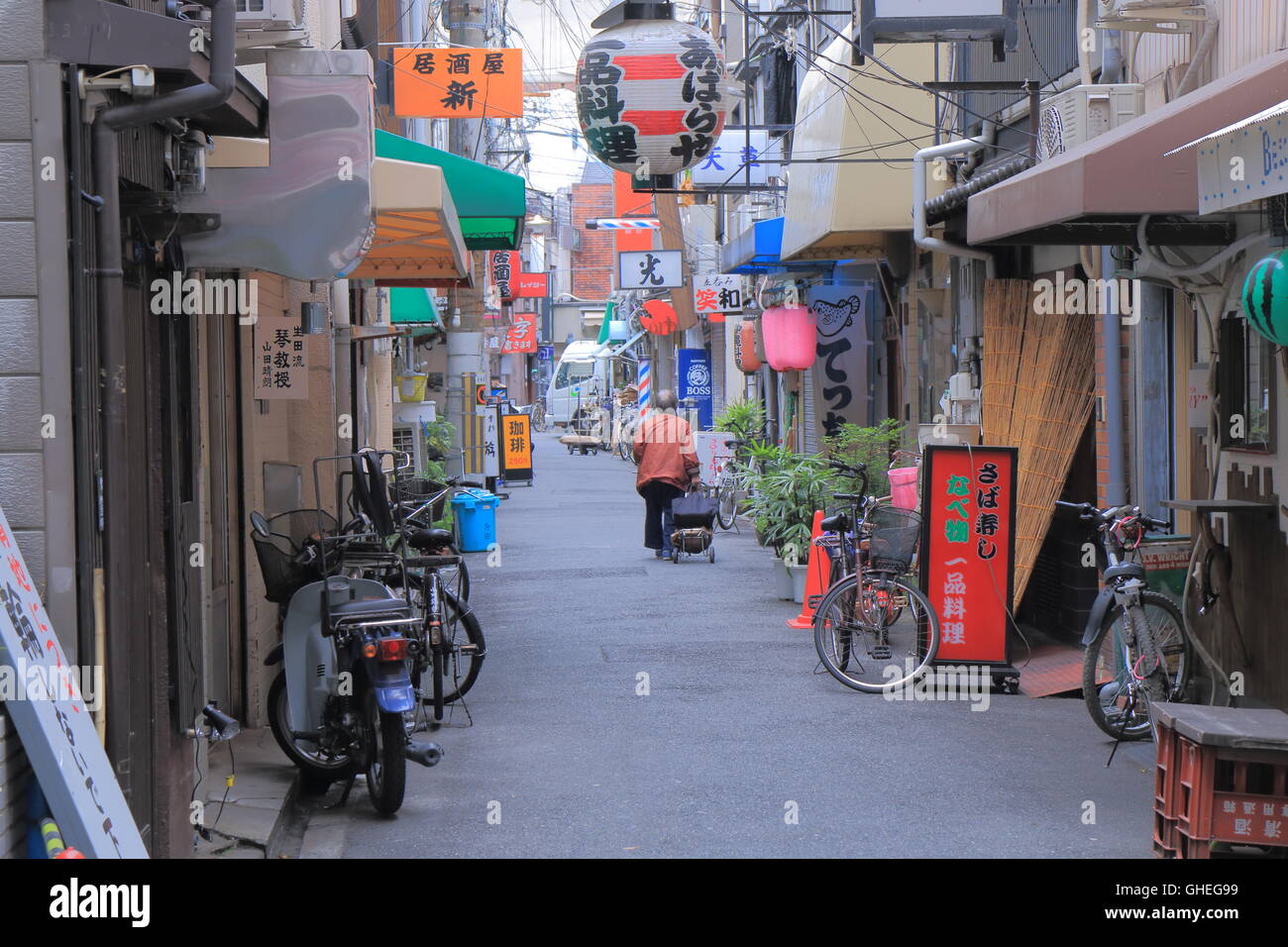 Una donna cammina giù per una strada tranquilla di Osaka in Giappone. Foto Stock