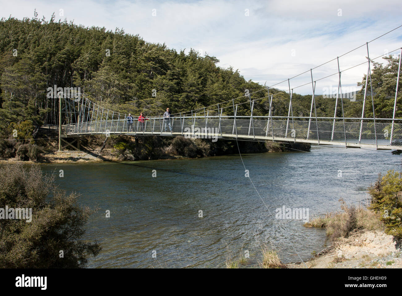 Un ponte di sospensione per gli escursionisti attraversa il deflusso del basso lago Mavora nelle Alpi del Sud della Nuova Zelanda. Foto Stock