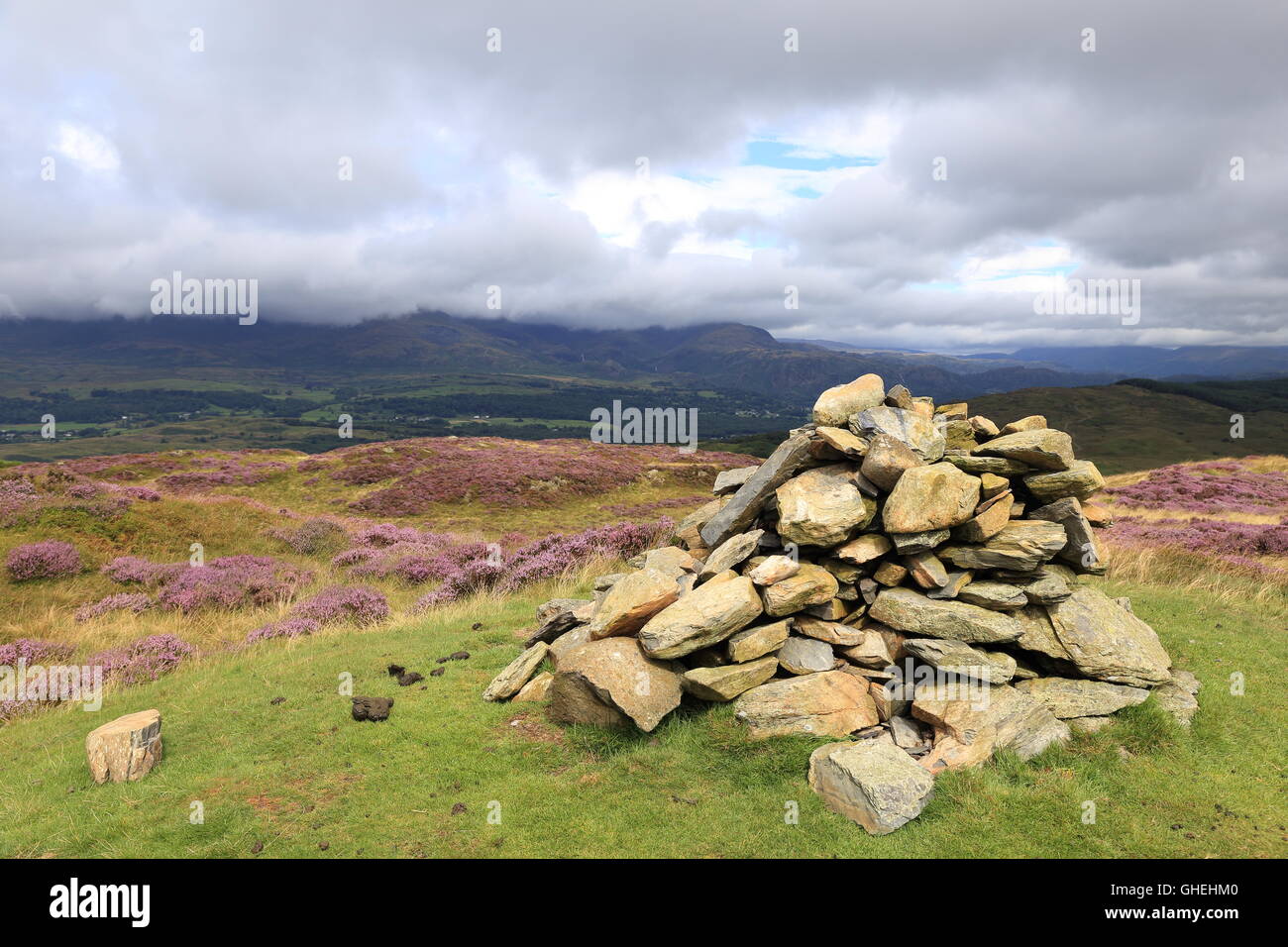 Cairn al vertice della parte superiore O'Selside in Cumbria Fells nel Lake District inglese. Il Cloud copre fino Coniston "uomo vecchio". Foto Stock