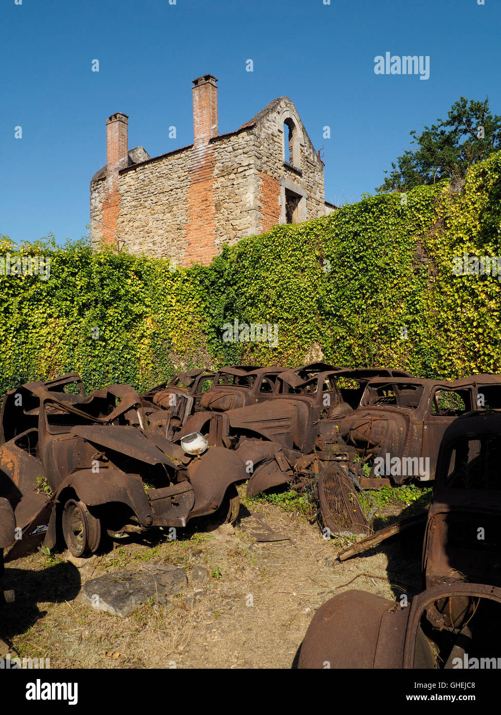 Oradour sur Glane War Memorial rovine del villaggio, Haute Vienne, in Francia con molti rusty auto rottamate Foto Stock