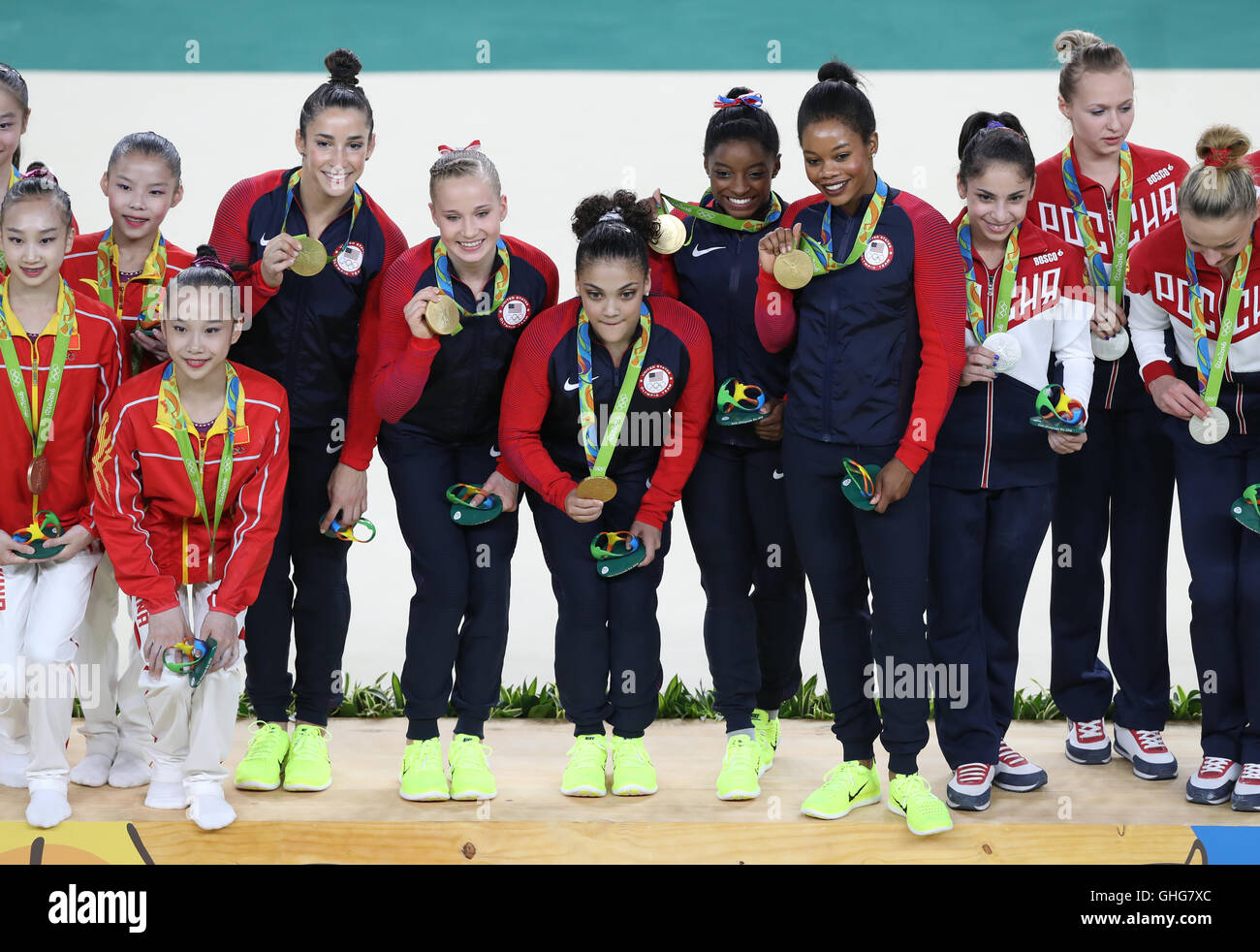 Il team USA celebrare vincere l'oro nel femminile della squadra di ginnastica a fianco finale silver medalists Russia (destra) e terzo bronze medalists Cina al Rio Olympic Arena il quarto giorno del Rio Giochi Olimpici, Brasile. Foto Stock