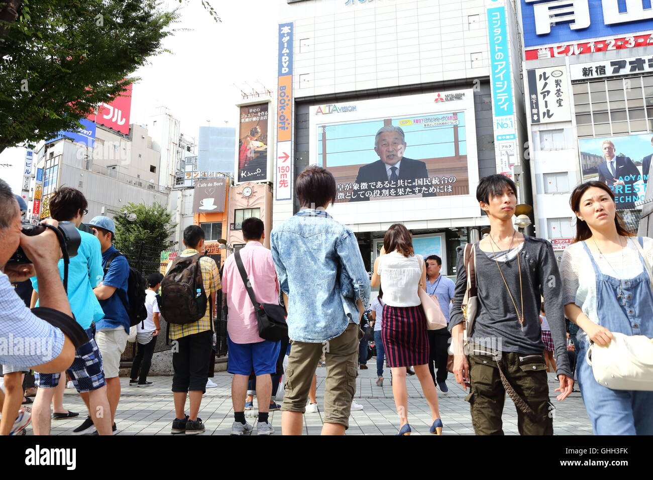 La gente guarda un grande schermo che mostra il giapponese Imperatore Akihito offre un messaggio video al pubblico a Tokyo in Giappone dal 8 agosto 2016. Il 82-anno-vecchio imperatore segnalato la sua intenzione di abdicare in un raro indirizzo teletrasmessa lunedì, esprimendo preoccupazioni per adempiere i suoi doveri dovuto alla diminuzione della salute. © AFLO/Alamy Live News Foto Stock