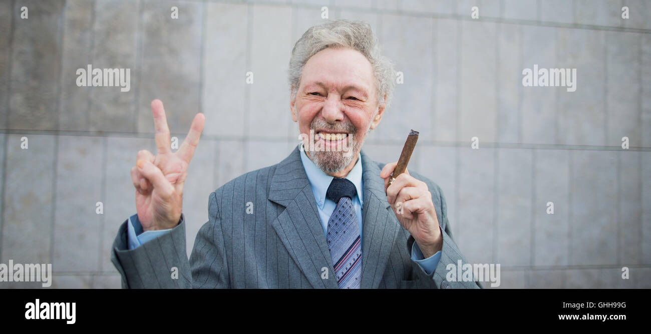 Duesseldorf, Germania. 28 Sep, 2016. Friedhelm Adolfs fuma un sigaro e dà il segno di vittoria al di fuori del tribunale regionale di Duesseldorf, Germania, 28 settembre 2016. Adolfs (78) ha conquistato una vittoria importante nella sua battaglia legale per evitare lo sfratto dal suo appartamento. Il tribunale regionale di Duesseldorf ha respinto una querela dalla sua padrona di casa. Foto: ROLF VENNENBERND/DPA/Alamy Live News Foto Stock