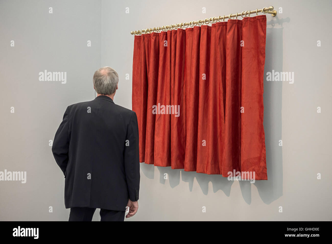 Duesseldorf, Germania. 28 Sep, 2016. Un visitatore guardando l'installazione Vorhang Rot (lit. Tenda Rossa) da Hans Peter Feldmann presso il Museo Kunstpalast, a Duesseldorf in Germania, 28 settembre 2016. La mostra "Hinter dem Vorhang, Verhüllung und Enthüllung seit der Renaissance - von Tizian bis Christo.' scorre dal 01.10.2016 fino al 22.01.2017. Foto: WOLFRAM KASTL/DPA/Alamy Live News Foto Stock