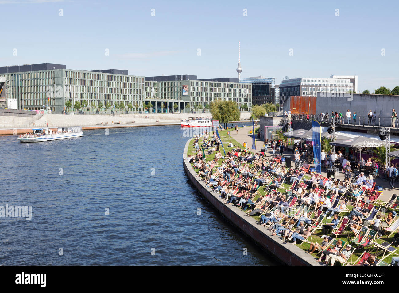 Fiume Spree con persone rilassarsi sulle sedie a sdraio a Capital Beach Bar, Berlino, Germania Foto Stock