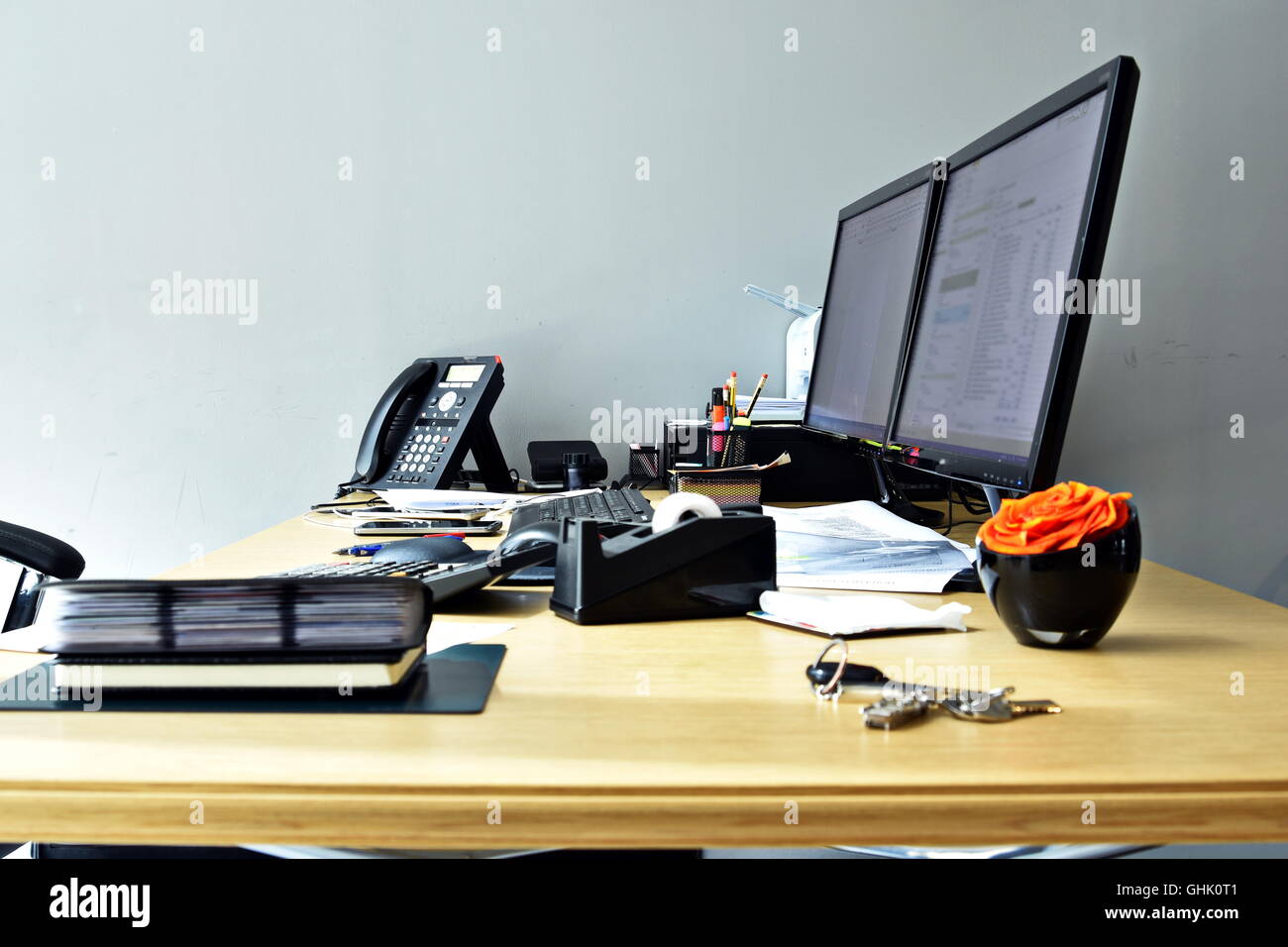 Occupato scrivania da ufficio con tutti gli elementi di lavoro Foto Stock
