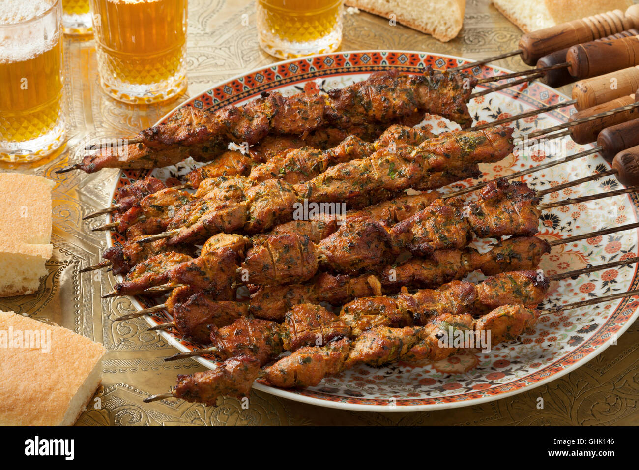Il piatto con il marocchino spiedini di agnello su una tabella con tè e pane Foto Stock