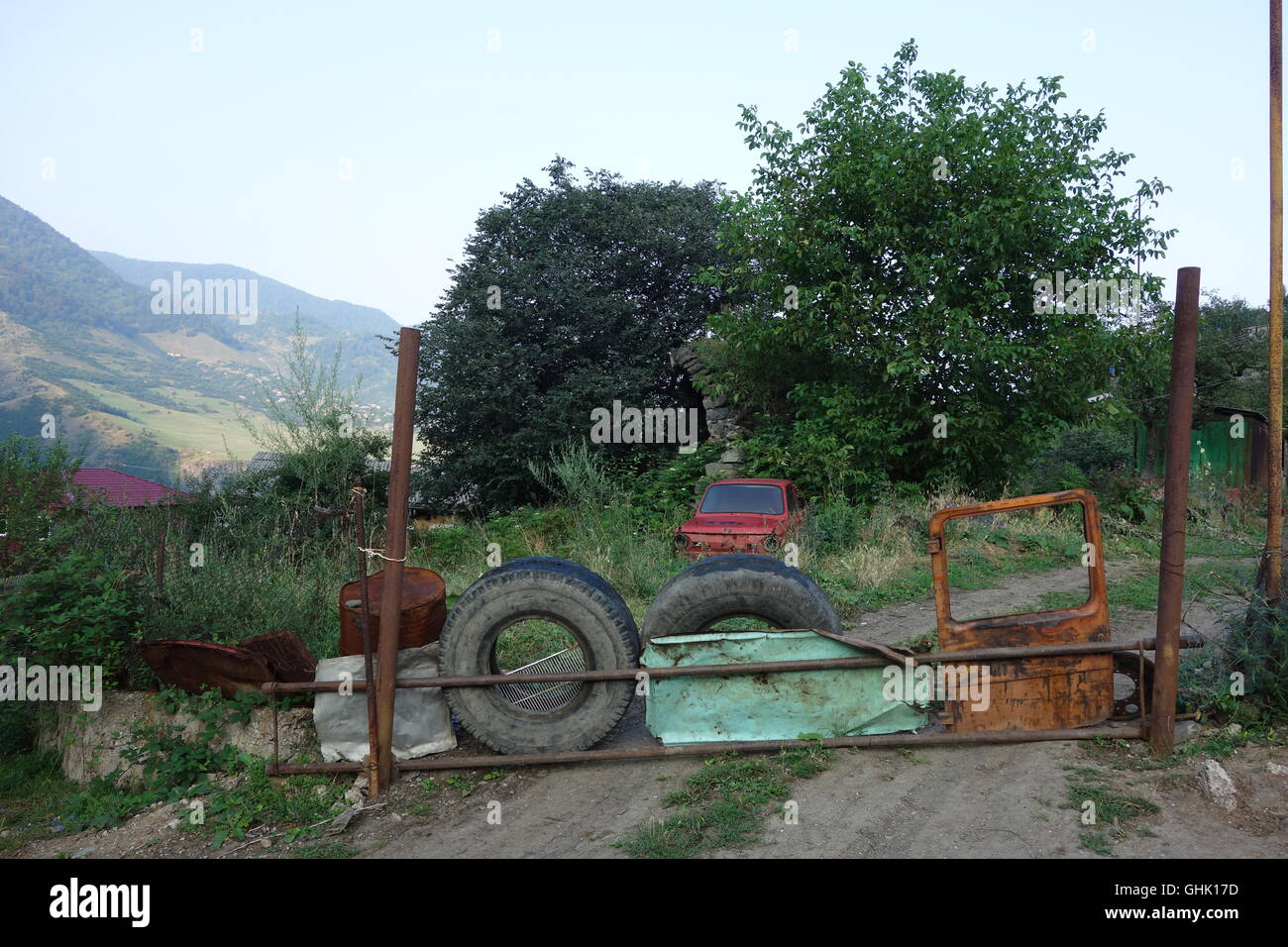 Fattoria Haghbat village nord Armenia barriera realizzata di vecchi pneumatici vettura in metallo e parti di ricambio per automobili Foto Stock