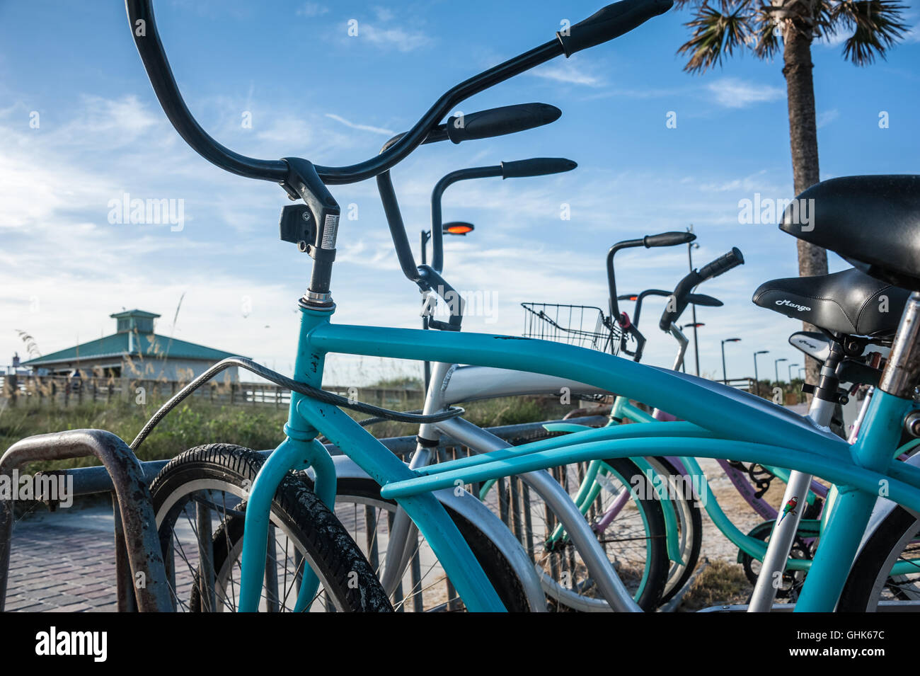 Spiaggia biciclette parcheggiate lungo il mattone lastricatore passerella a Jacksonville Beach Pier nella spiaggia di Jacksonville, Florida, Stati Uniti d'America. Foto Stock