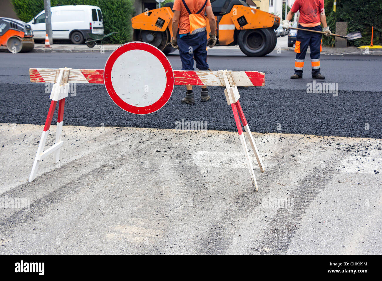 I lavoratori sulla strada di asfaltatura durante lavori di riparazione Foto Stock