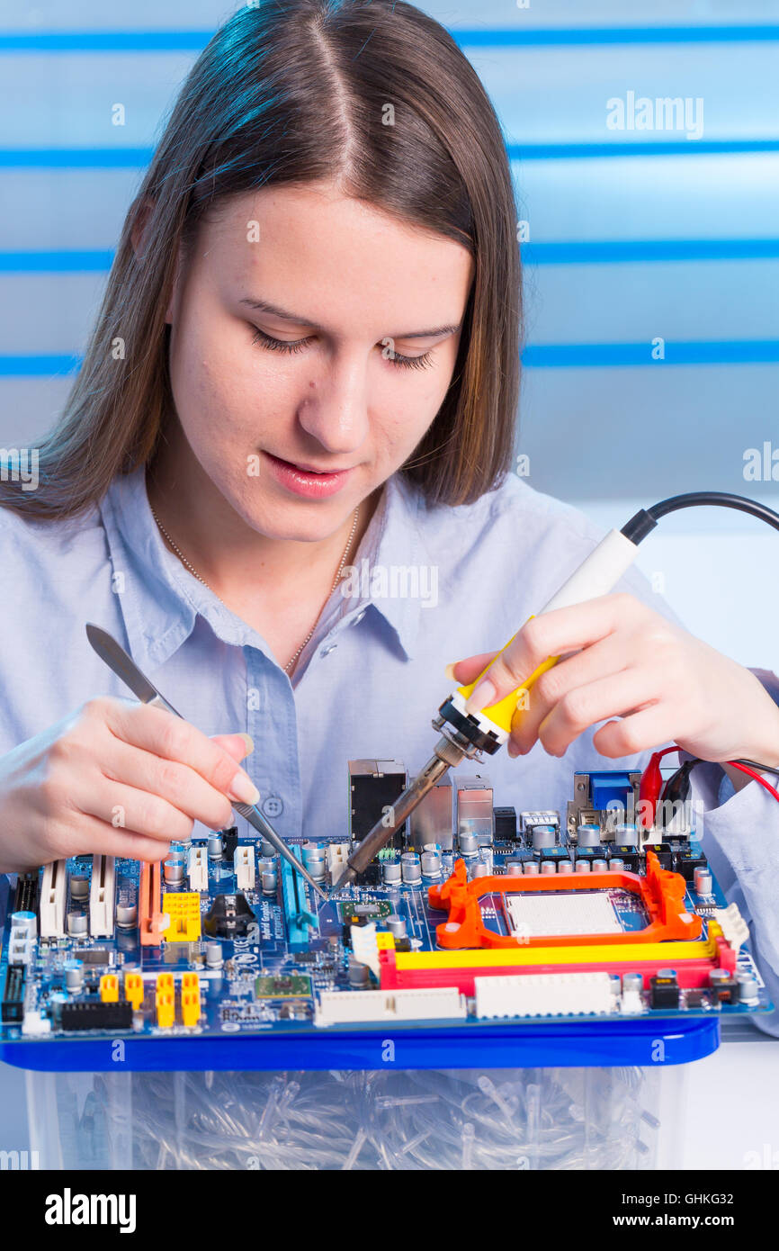 Giovane donna riparazione tecnico dispositivo elettronico Foto Stock