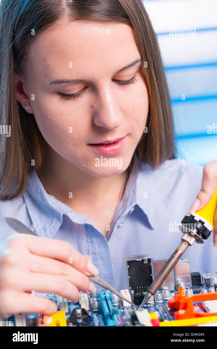 Giovane donna riparazione tecnico dispositivo elettronico Foto Stock