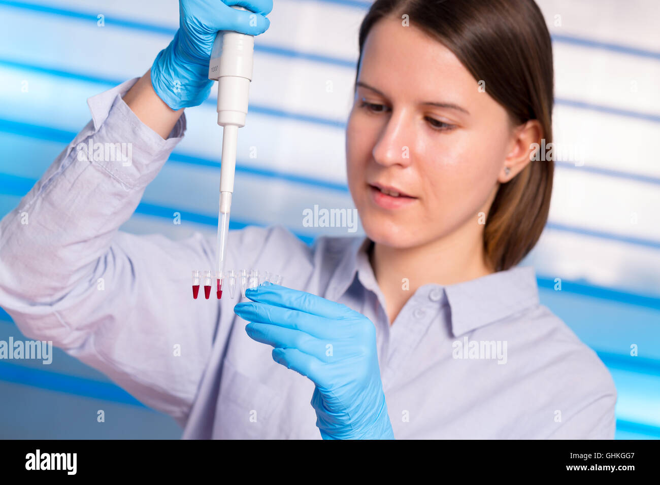 Giovane tecnico con il pipettaggio strope PCR Foto Stock